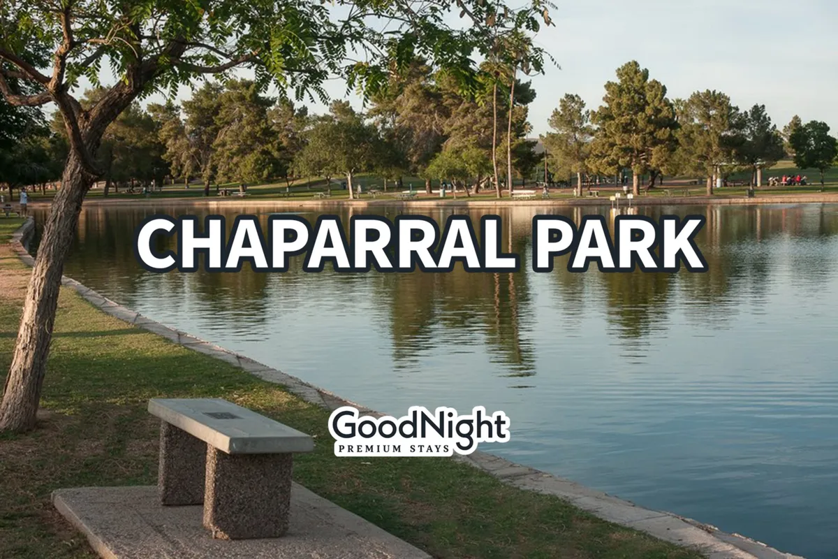 A serene park setting with a pond reflecting the sunset, surrounded by tall trees. A wooden bench sits along the water's edge, inviting visitors to pause and enjoy the peaceful surroundings. The park atmosphere is calm and welcoming, ideal for walking, relaxing, or having a picnic.