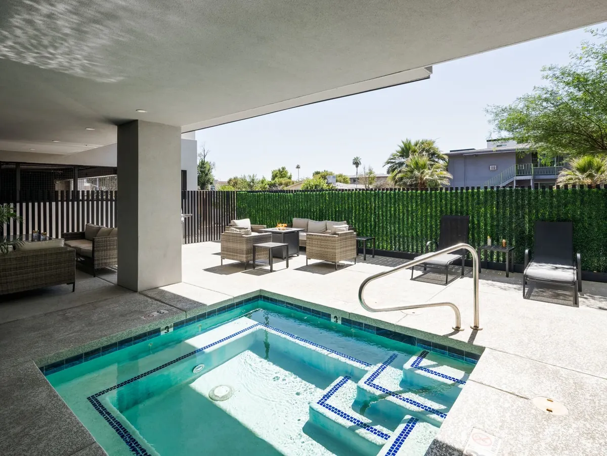 An inviting outdoor spa pool area with ample seating and lush greenery. The space is designed for relaxation and social gatherings, with comfortable loungers and an open ambiance that encourages connection.